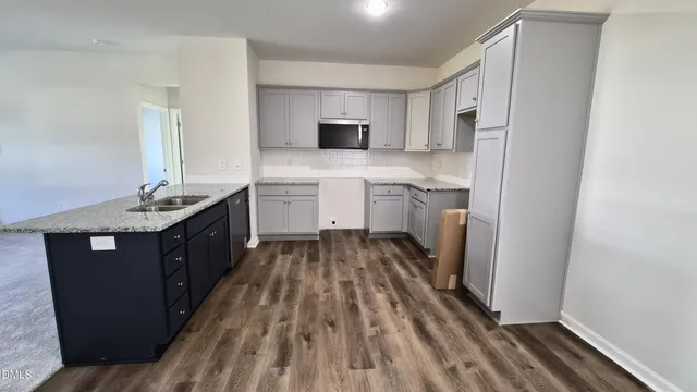 a kitchen with a sink a stove top oven and white stainless steel appliances