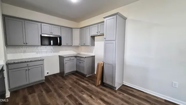 a kitchen with a sink a microwave a refrigerator and cabinets