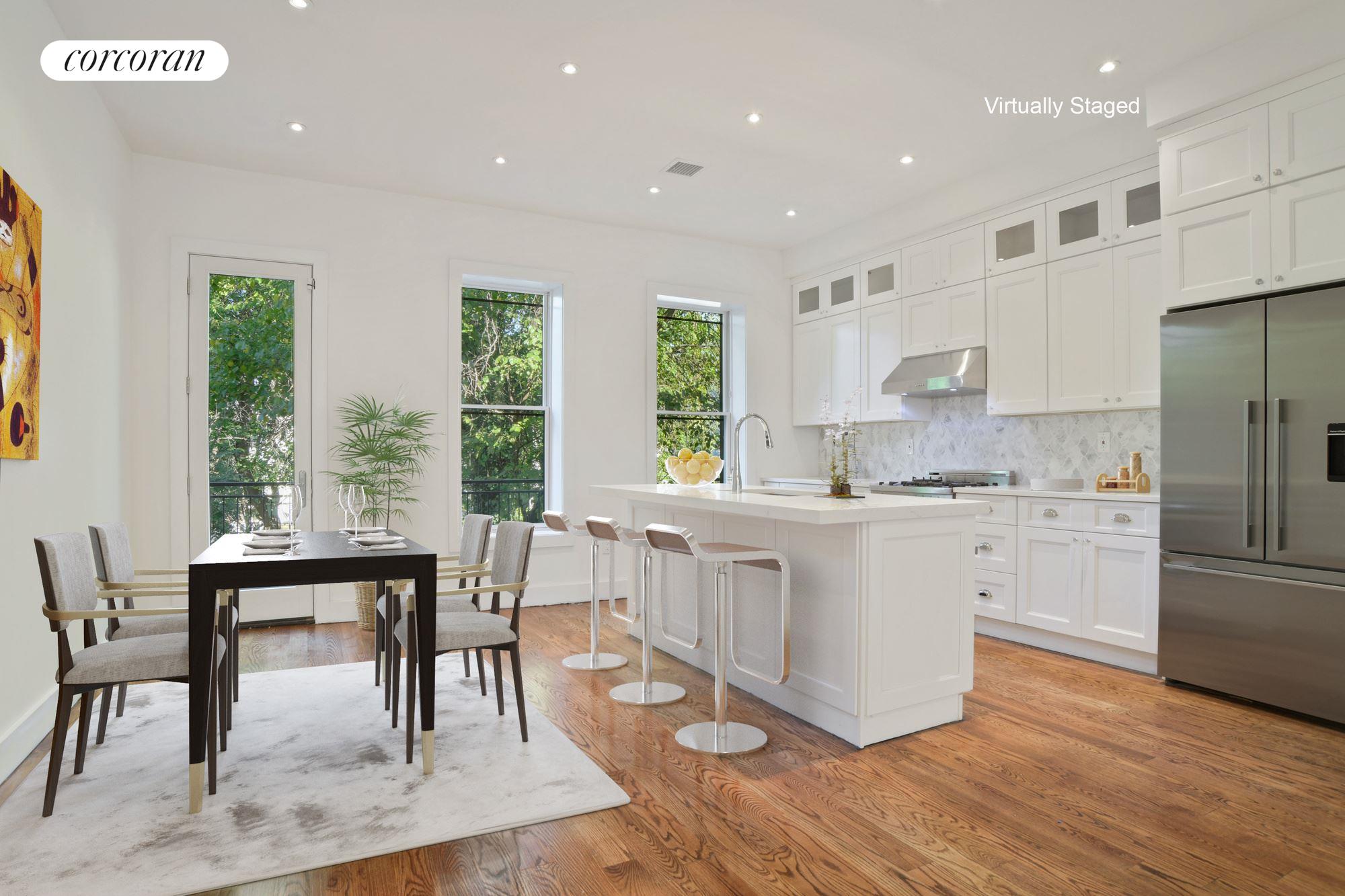 a kitchen with white cabinets and wooden floors