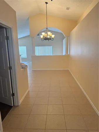 a view of a livingroom with a chandelier fan and door