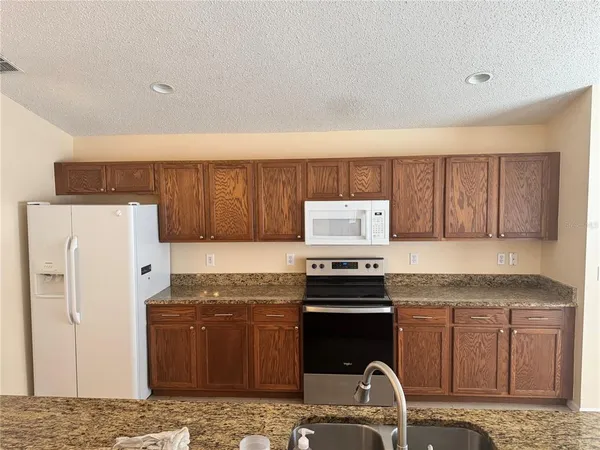 a kitchen with stainless steel appliances granite countertop a refrigerator sink and stove