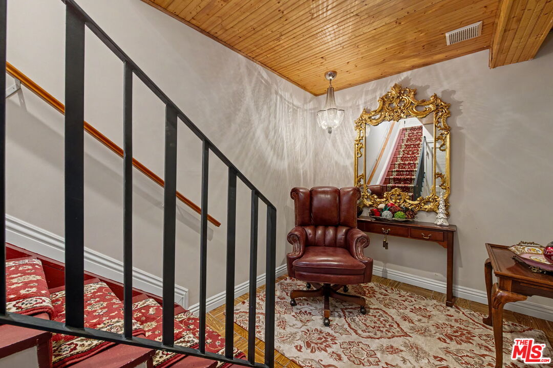 204 Foothill Road Beverly Hills, CA 90210 - Photo 13 of 38 a view of staircase with wooden floor and a rug