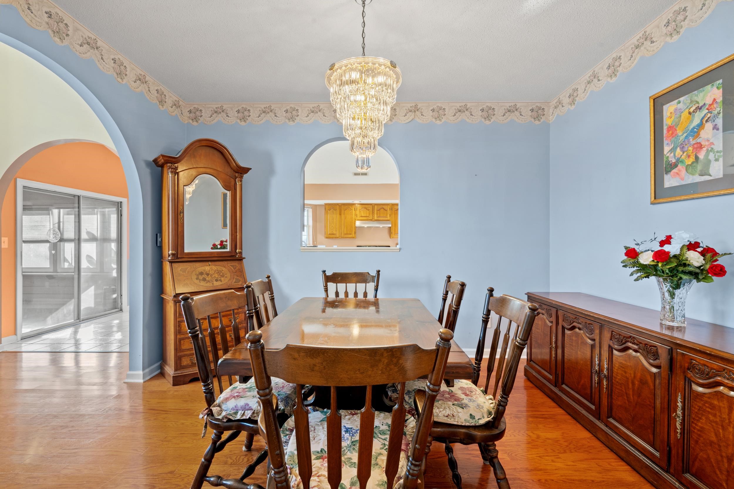 3106 Robyn Court Little River, SC 29566 - Photo 7 of 37 Dining space with arched walkways, light wood-style floors, a chandelier, and healthy amount of natural light