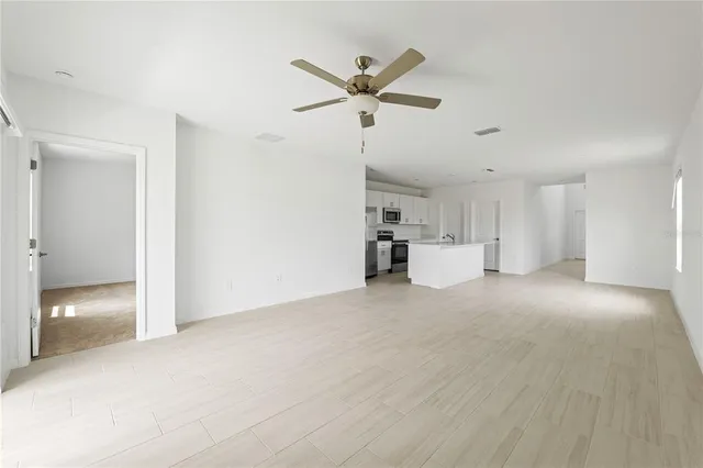 a view of a livingroom with a ceiling fan and window