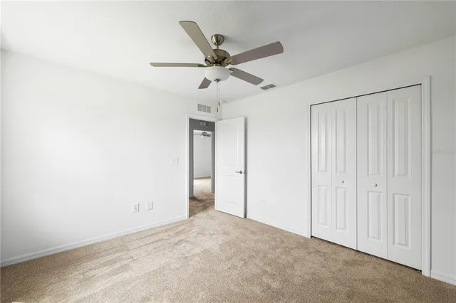 an empty room with a window and a ceiling fan