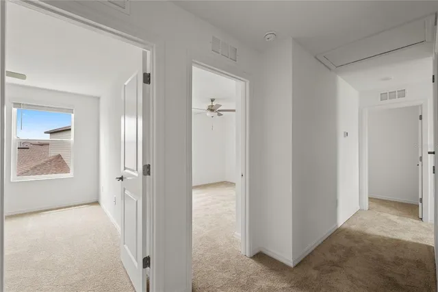 an empty room with a window and a fan