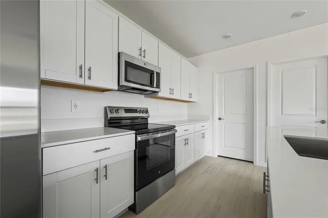 a kitchen with white cabinets and white appliances