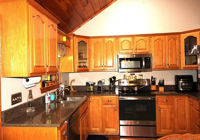 a kitchen with stainless steel appliances a sink a stove and a microwave