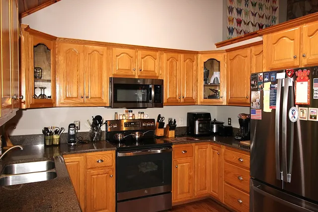a kitchen with stainless steel appliances granite countertop a refrigerator and a sink