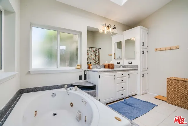 a bathroom with a tub sink and mirror