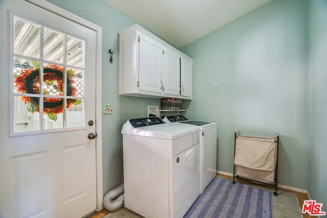 a utility room with wooden floor washer and dryer