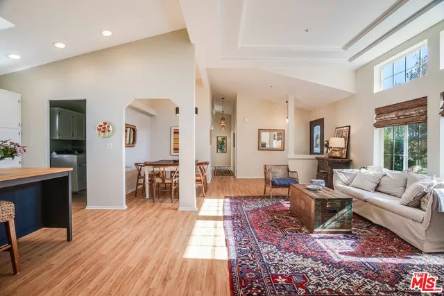 a living room with furniture large window and wooden floor