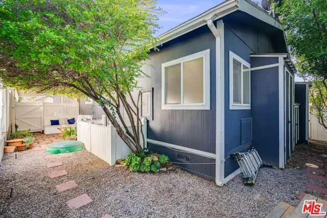 a view of a street with potted plants and large trees