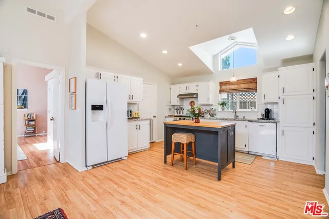 a open kitchen with white cabinets and stainless steel appliances