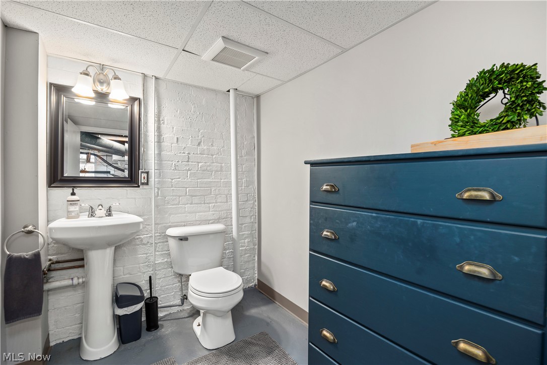 26019 Lake Road Bay Village, OH 44140 - Photo 33 of 40 Pedestal sink with chrome fixtures and a framed mirror under sconce lighting
