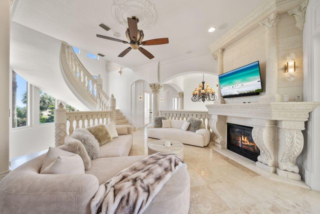 a large kitchen with a large counter top space a sink stainless steel appliances and cabinets