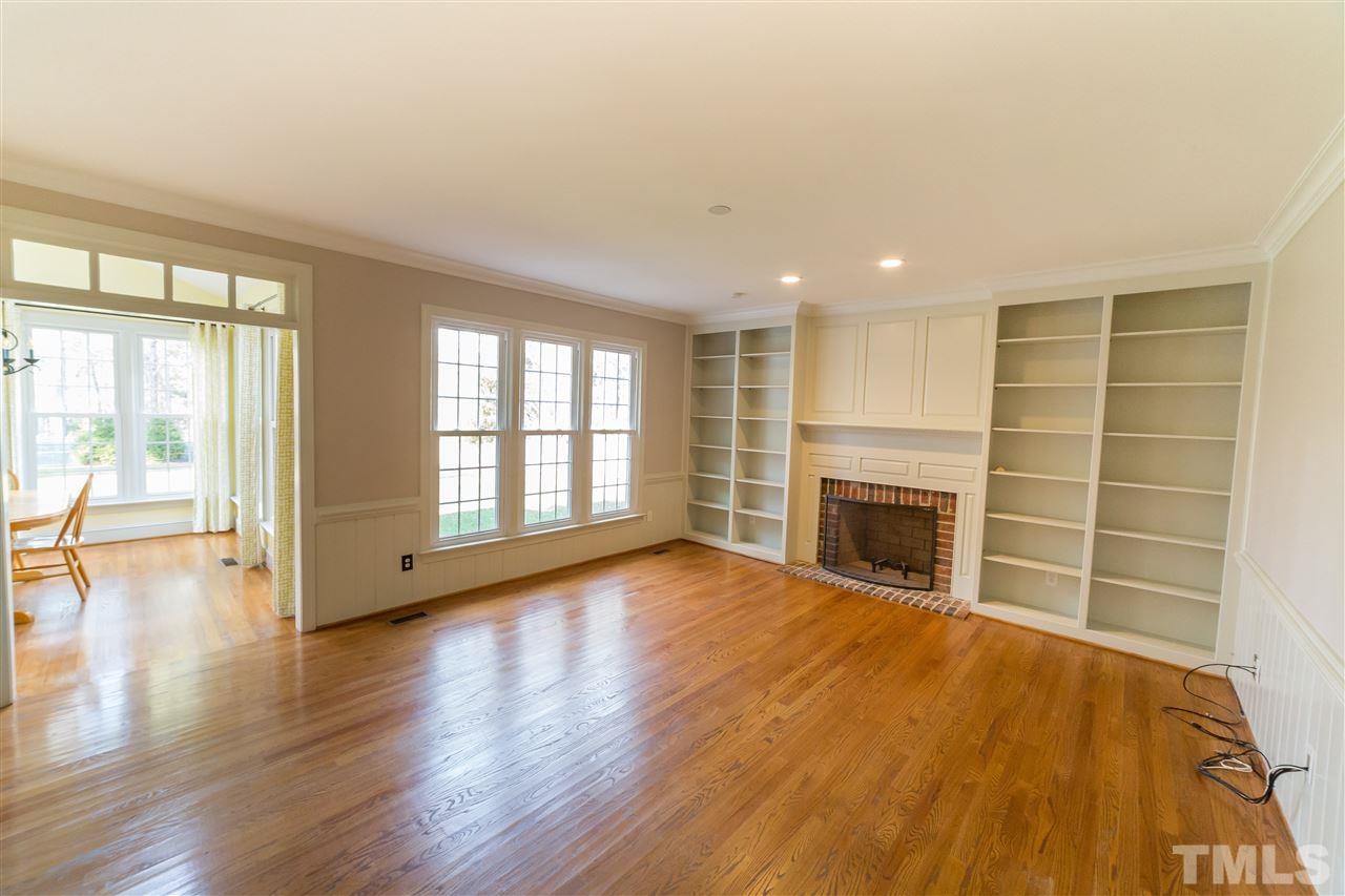 5228 Caber Road Raleigh, NC 27613 - Photo 8 of 25 a view of an empty room with a fireplace and a window