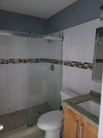 a bathroom with a granite countertop sink toilet and shower