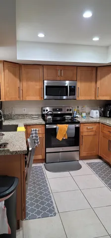 a kitchen with stainless steel appliances granite countertop a stove a sink and a microwave