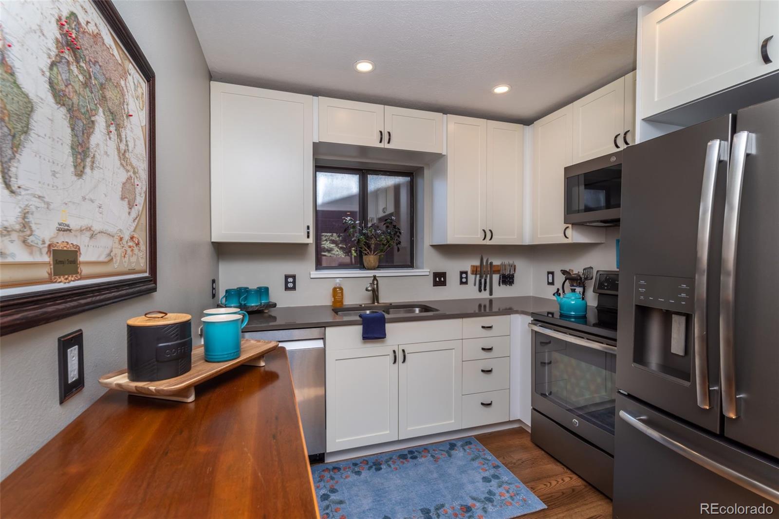 1633 4th Street, Unit C Boulder, CO 80302 - Photo 11 of 40 a kitchen with stainless steel appliances granite countertop a refrigerator sink and microwave