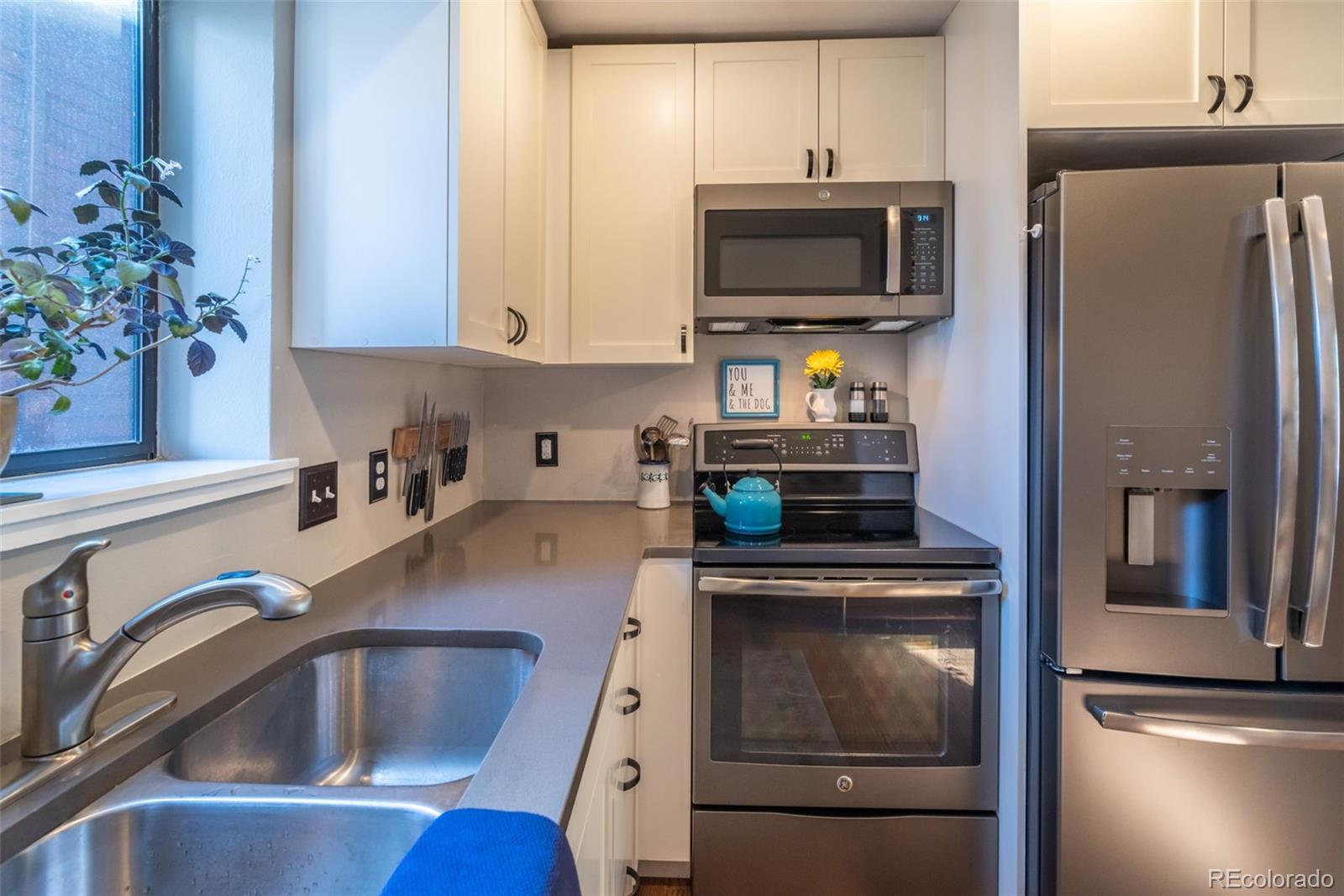 1633 4th Street, Unit C Boulder, CO 80302 - Photo 12 of 40 a kitchen with stainless steel appliances a sink a stove a microwave and refrigerator