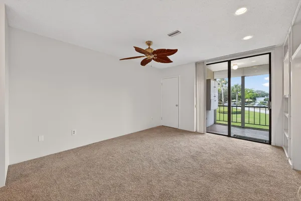 an empty room with fan and windows