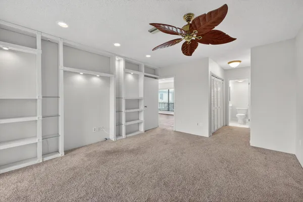 a view of an empty room and kitchen view