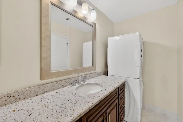 a bathroom with a granite countertop sink and a mirror