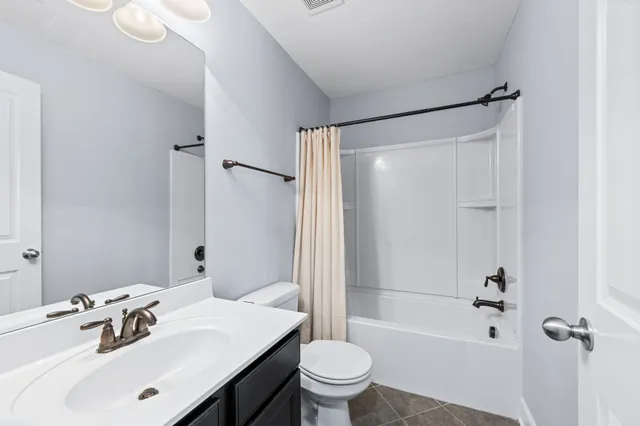 a view of an empty room with wooden floor and staircase