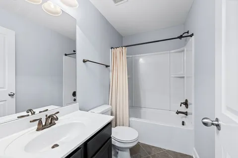 a view of an empty room with wooden floor and staircase