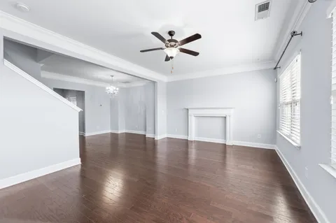 a view of a livingroom with wooden floor and a ceiling fan