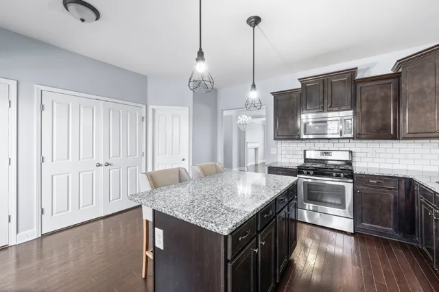 a kitchen with granite countertop a refrigerator and a sink