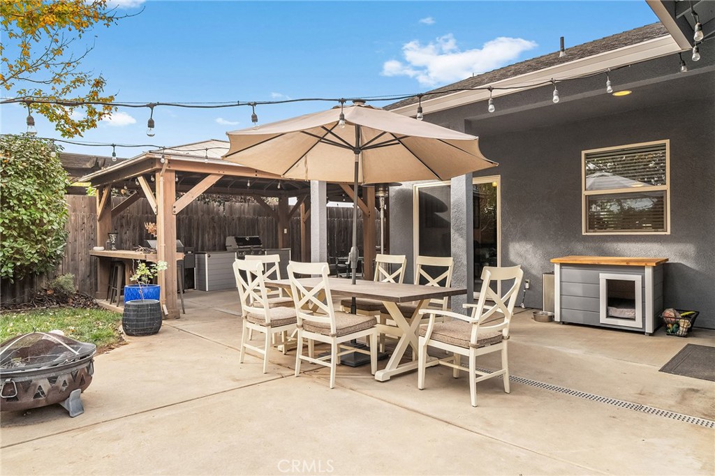 1563 Champlain Way Chico, CA 95973 - Photo 36 of 49 a view of a patio with dining table and chairs under an umbrella