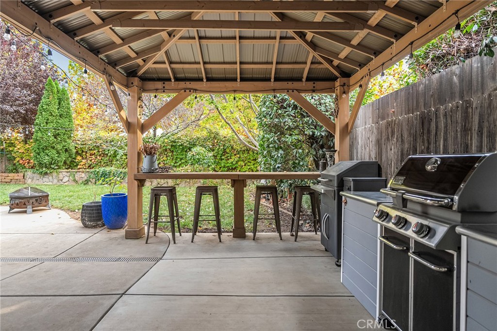 1563 Champlain Way Chico, CA 95973 - Photo 6 of 49 a view of a patio with table and chairs under an umbrella with a small garden