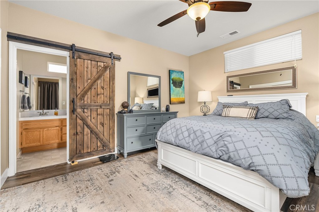 1563 Champlain Way Chico, CA 95973 - Photo 7 of 49 a bedroom with a large bed and a chandelier fan