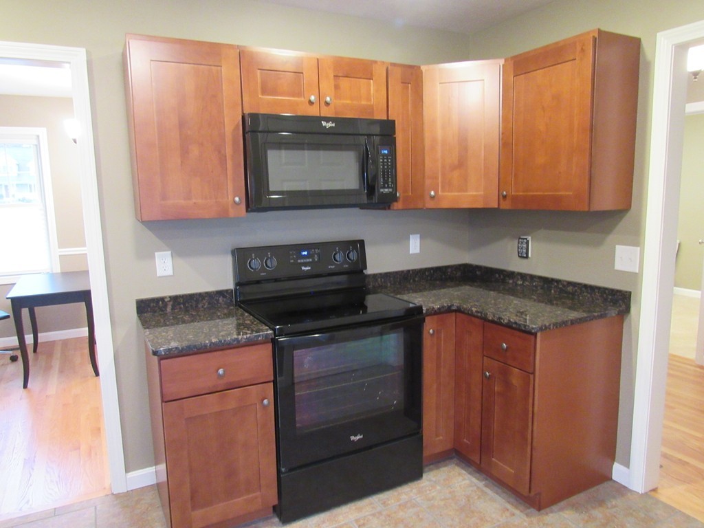 33 Strong Road Southampton, MA 01073 - Photo 8 of 18 a kitchen with granite countertop a stove and a microwave
