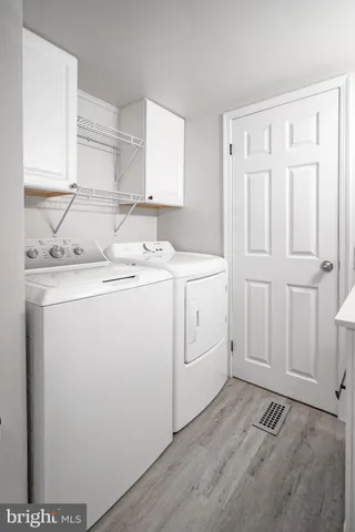 a utility room with cabinets washer and dryer