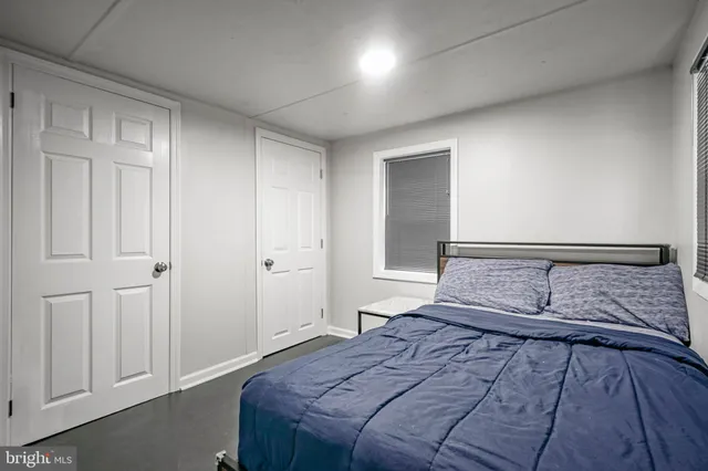 a bedroom with a large bed and wooden floor