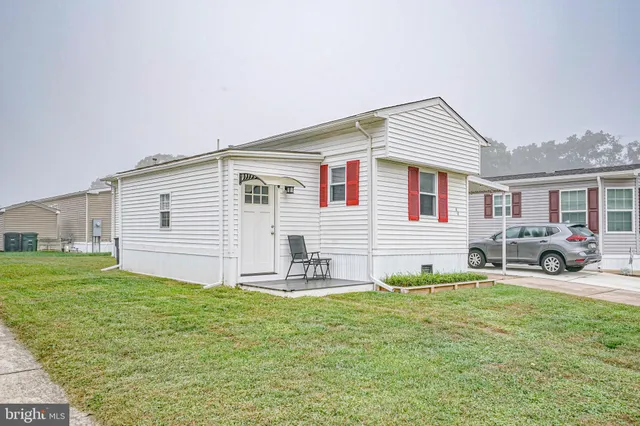 a view of a house with a yard and sitting area