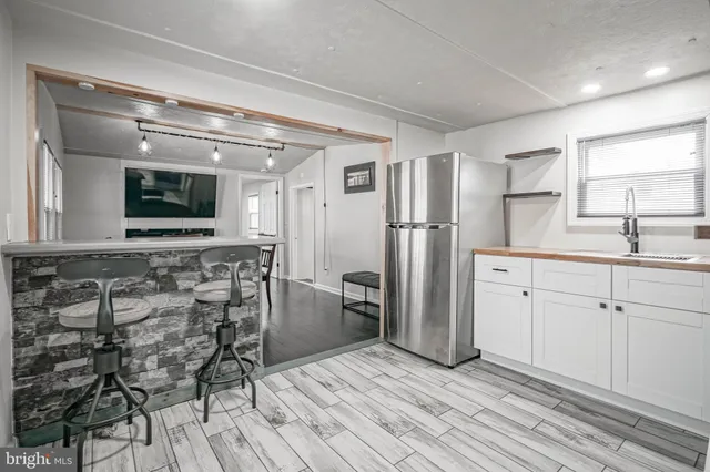 a kitchen with stainless steel appliances kitchen island granite countertop a refrigerator and a stove top oven