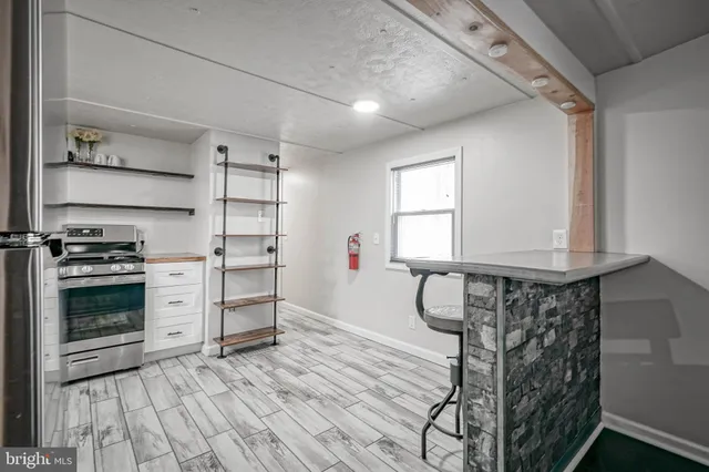 a kitchen with white cabinets and window