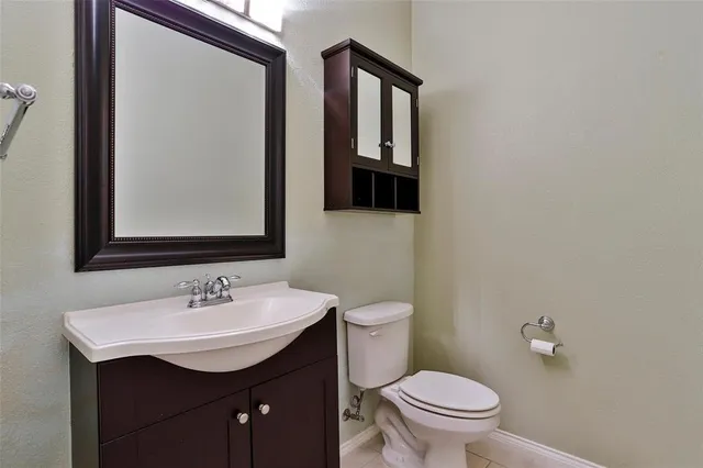 a bathroom with a toilet a sink and mirror