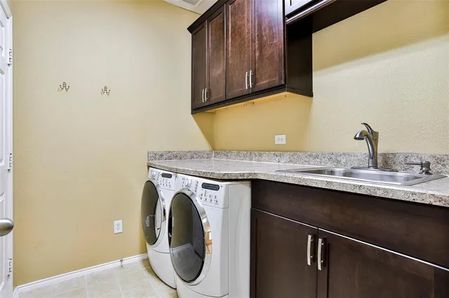a utility room with granite countertop a sink and a stove