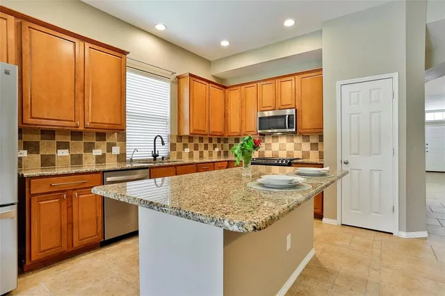a kitchen with stainless steel appliances granite countertop sink and window