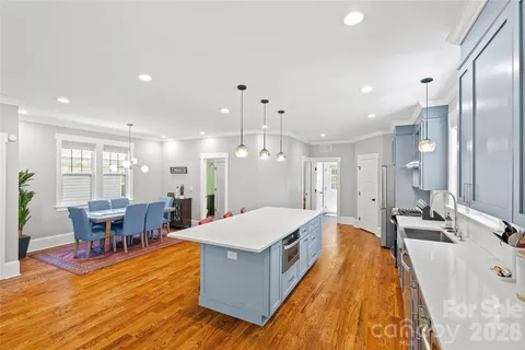 a large living room with stainless steel appliances kitchen island a large window in the center