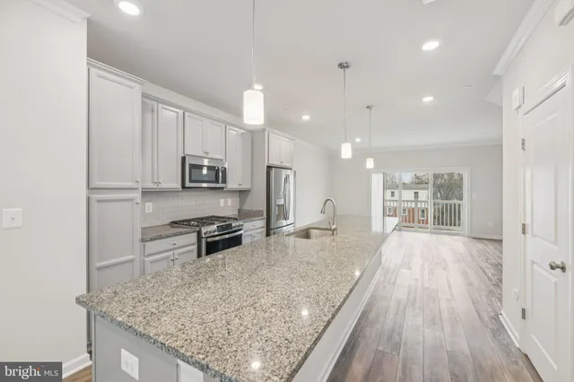 a view of a kitchen with wooden floor and windows