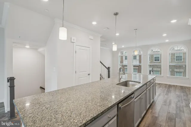 a large kitchen with kitchen island a large counter top space a sink stainless steel appliances and cabinets