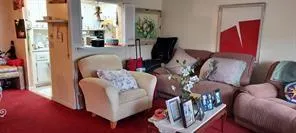 a living room with furniture a flat screen tv and a window