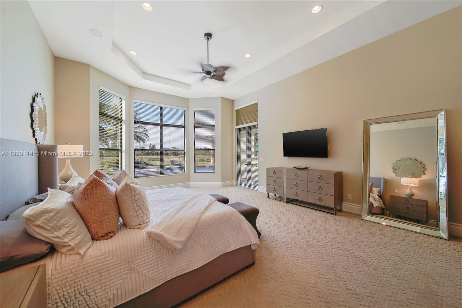 2863 Lake Ridge Lane Weston, FL 33332 - Photo 18 of 60 a spacious bedroom with a bed and a flat screen tv