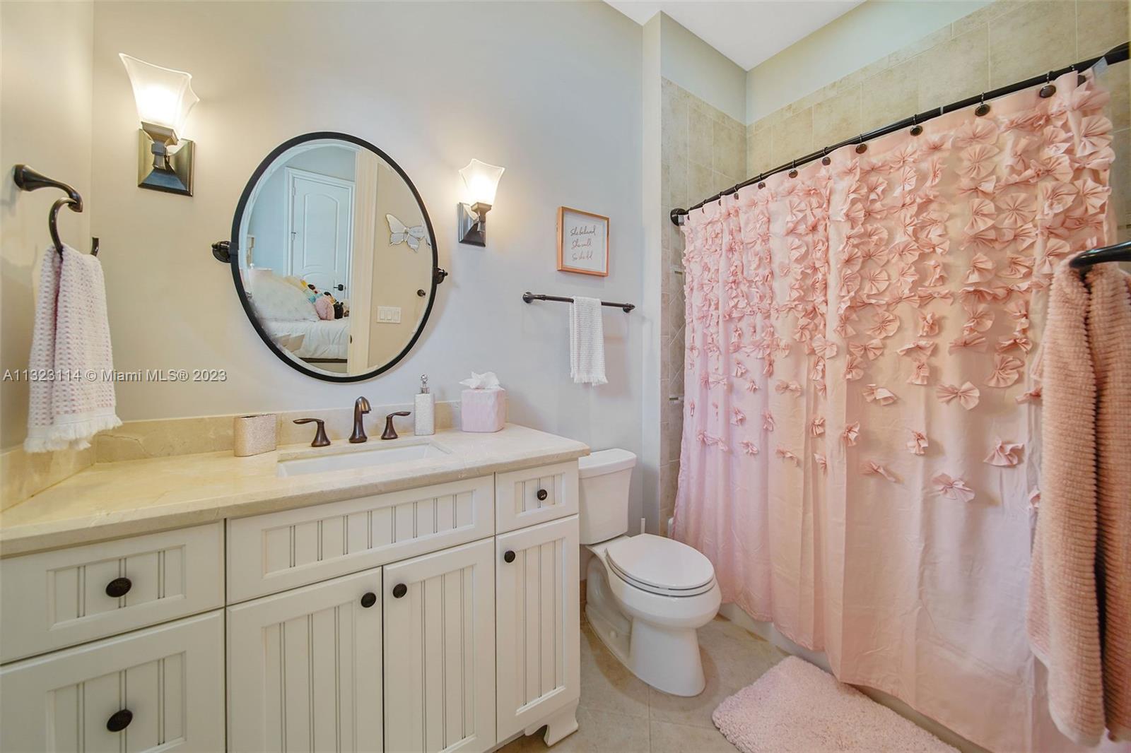 2863 Lake Ridge Lane Weston, FL 33332 - Photo 31 of 60 a bathroom with a toilet sink vanity and mirror